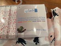 Close up of Splash brand fabric shower curtain label and packaging. Shows size 70x72 inches (178x183 cm) and floral pattern with birds.