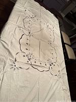 White Irish linen tablecloth with Battenburg lace laid out, showing overall design and condition with light creases.