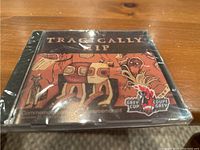 Front cover of the commemorative Tragically Hip CD showcasing Indigenous style artwork and Grey Cup logo.