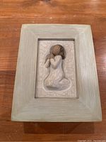 Front view of wooden Willow Tree memory box showing a carved woman figurine in kneeling position on the box lid.