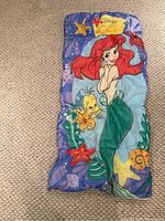 Full view of youth sleeping bag showing Ariel and Flounder print, with ocean background and starfish accents.