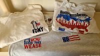 Three vintage T-shirts laid flat on a surface: two FDNY Twin Towers shirts and one Hands Across America shirt.