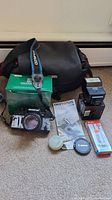 Full lot showing Olympus SuperZoom 3500 camera with strap, original green Olympus box, black camera case, external Olympus flash, instruction manual, Canon lens cap, lens cap holder, and boxed accessory.
