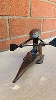 Front angle view of the metal kayaking sculpture showing figure and paddle detail.