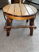 Front view of the round wooden footstool showing slatted oak top and hickory legs with a natural rustic finish.