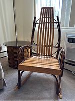 Front view of the rustic hickory and oak rocking chair showing its slatted back and seat with curved hickory frame