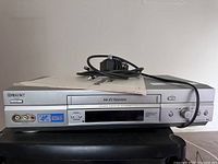Top and front view of the Sony SLV-N570 VCR with power cord and remote on top.