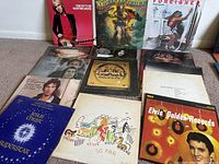 Overview photo showing 14 vintage vinyl LP record albums arranged on the floor, including Jesus Christ Superstar, Tom Petty, Molly Hatchet, Foreigner, Elvis Golden Records and more.