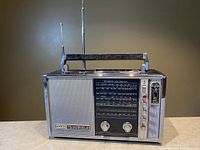 Front view of the Sanyo Transworld 6 band radio showing speaker grille, tuning dials, and logo.