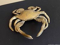 Top angled view of the vintage brass crab ashtray showing detailed legs and claws on black background