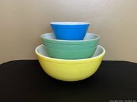 Stacked view from front showing the large yellow, medium green, and small blue bowls nested together.