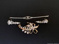 Overall photo showing the bracelet, earrings, and brooch all laid out on a dark background.