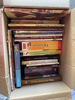 Box of assorted children’s fiction and nonfiction books showing titles like 'Brown Paper Teddy Bear', 'Look and Find: Beauty and the Beast', 'Children's Dictionary', and 'Comics Treasury'.