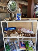 Photo showing full view of shelf with makeup mirror, mop heads, cleaning cloths, and loofah scrubbers