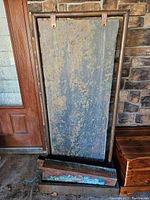Full view of large slate waterfall panel standing vertically inside a copper tube frame with base water catch basin.