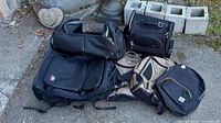 Photo of all six bags grouped together showing various Swiss Gear, Herschel, and Skyway bags including backpacks and duffle bag.