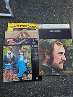 Seven vinyl record albums by ABBA, KC & The Sunshine Band, Barbra Streisand & Kris Kristofferson, Richard Harris, and others arranged on ground showing album covers.