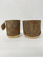 Two Acadia wood planters displayed side by side showing bark exterior and size.