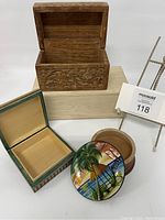 All three boxes shown, including square wood box with checkerboard carving, open rectangular floral wood box, and round painted Cuba souvenir box with lid removed