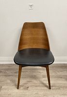 Front view of bentwood chair with walnut stain and black vinyl padded seat cushion.