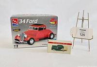 AMT 1934 Ford Coupe plastic model box with red car image, 1955 Chevrolet Bel Air small boxed model car, lot tag on display stand