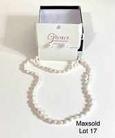 Pearl necklace, bracelet, and pearl stud earrings displayed with brand card and gift box