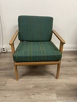 Front view of mid century modern teak lounge chair with green and teal bouclé corduroy cushions.