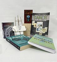Photo showing Santa Muerte tarot deck box, Zener ESP cards, three books with tarot and kabbalah themes, and a metal display easel stand.