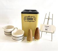 Full view of the vintage cookie canister, cream and sugar set, and wooden salt and pepper shakers against a plain background.