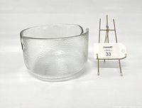 Clear textured crystal glass bowl by Rosenthal Studio Line, displayed next to a small easel with a lot number tag.