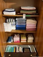 Shelves containing neatly folded large towels, pillowcases, washcloths, and other linens