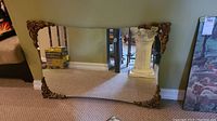 Front view of large rectangular wall mirror showing four decorative corner frames with carved patterns and bronze-gold finish.