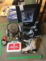Full lot on carpet: includes Bauer skates, figure skates, racquetball racquet, first aid kit, framed Ed Belfour photo.