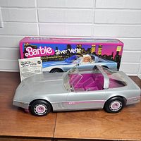 Silver Barbie Dream Vette convertible toy car with pink interior and original box in background.
