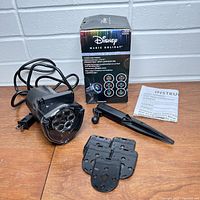 Photo of projection light unit, black plastic with 6 discs to change, power cord, instruction manual and original box