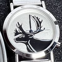 Close-up photo of the silver-tone watch dial featuring a large black moose head silhouette with antlers and silver hands.