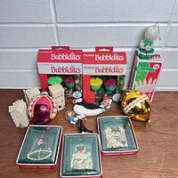 Lot showing all items together including NOMA Bubblelights, boxed Fantasy Decor ornaments, vintage glass ball ornaments, wooden houses, boxed white candles, and bird ornament.