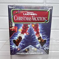 Front of sealed game box showing title and artwork of Clark Griswold tangled in holiday lights.