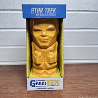Front view of ceramic mug shaped as Captain Kirk tiki figure in original box with Star Trek branding