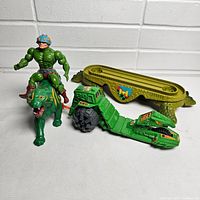 He-Man figure on Battle Cat toy with green Battle Cat vehicle and play mat