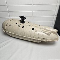 Full assembled view of the beige plastic Rebel Transport with black turret on top and detailed molded surfaces showing wear and stickers.