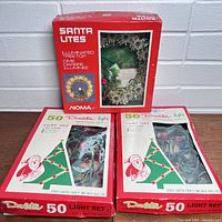 Two boxes of 50-light Decorator vintage cactus Christmas light sets in original packaging and a boxed red Noma Santa Lites illuminated tree top star.
