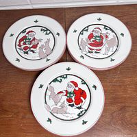 Stacked plates showing Santa with rabbit and holly border design