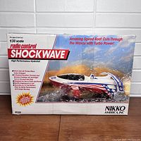 Box front showing Nikko America Shockwave 1/30 scale radio control high performance hydrofoil boat with racing graphics.