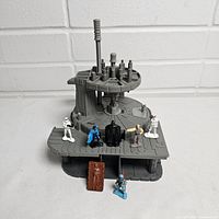 Gray plastic vintage Star Wars Bespin World micro playset with metal die-cast figures placed on and around it including Darth Vader, Luke Skywalker, stormtrooper, blue cloaked figure, Boba Fett, and Han Solo in carbonite piece.