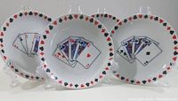 Photo showing three of the four ceramic plates with playing card designs and suit symbol borders.