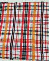 Close-up photo showing detailed multi-colored plaid woven pattern of the tablecloth.