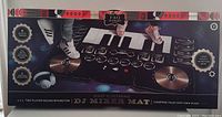 Full view of the unopened FAO Schwarz DJ mixer mat box showing piano keys, turntables, and various music mixing buttons printed on the mat.