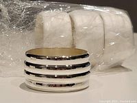 Close-up image of one silverplated napkin ring showing the polished finish and triple band design.