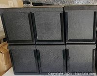 Photo showing six dark gray heavy duty plastic boxes arranged in two rows of three, all with textured fronts and handles.